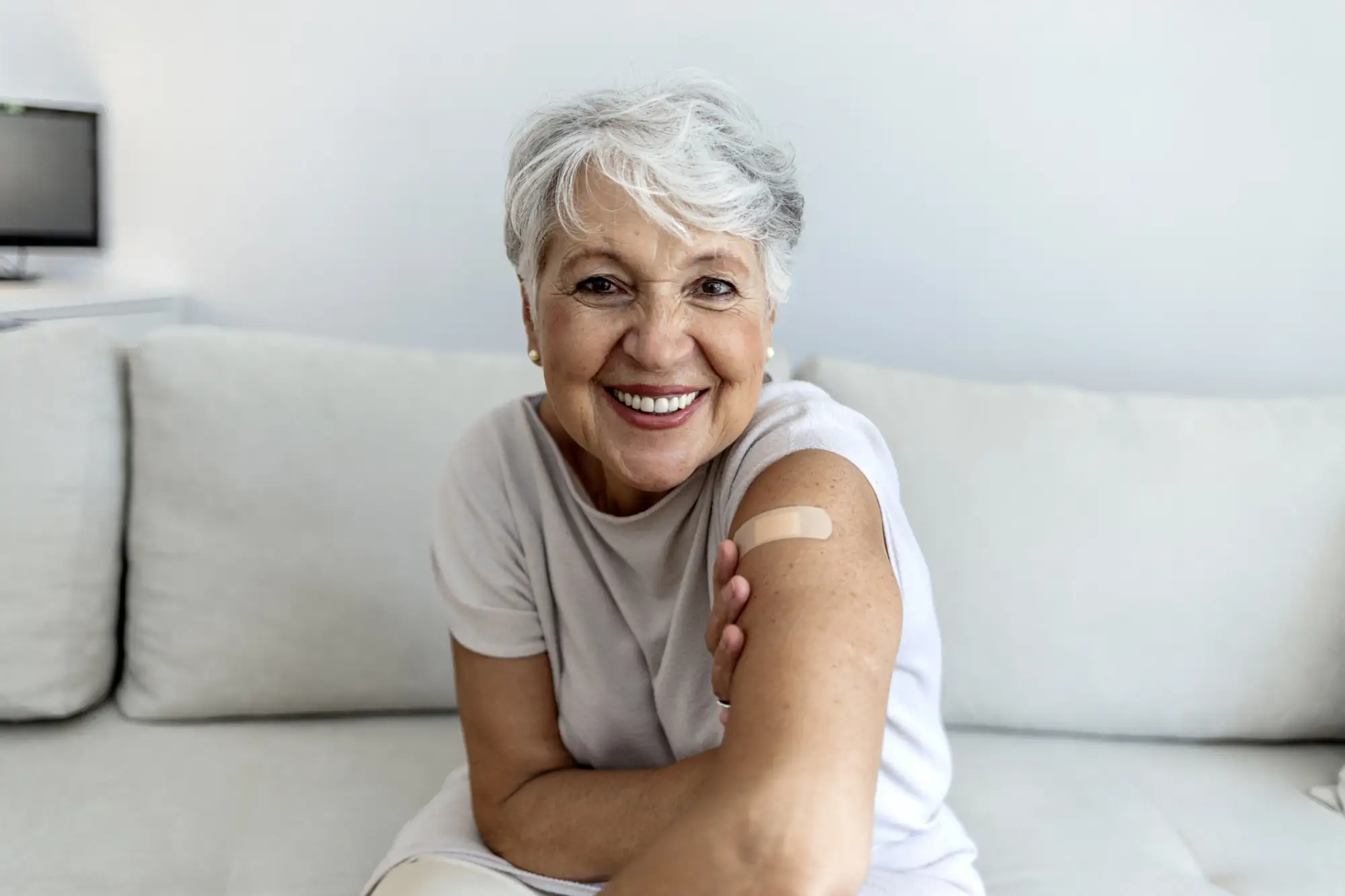 iStock-1340445914 senior woman with a bandaid on her arm after receiving the flu shot
